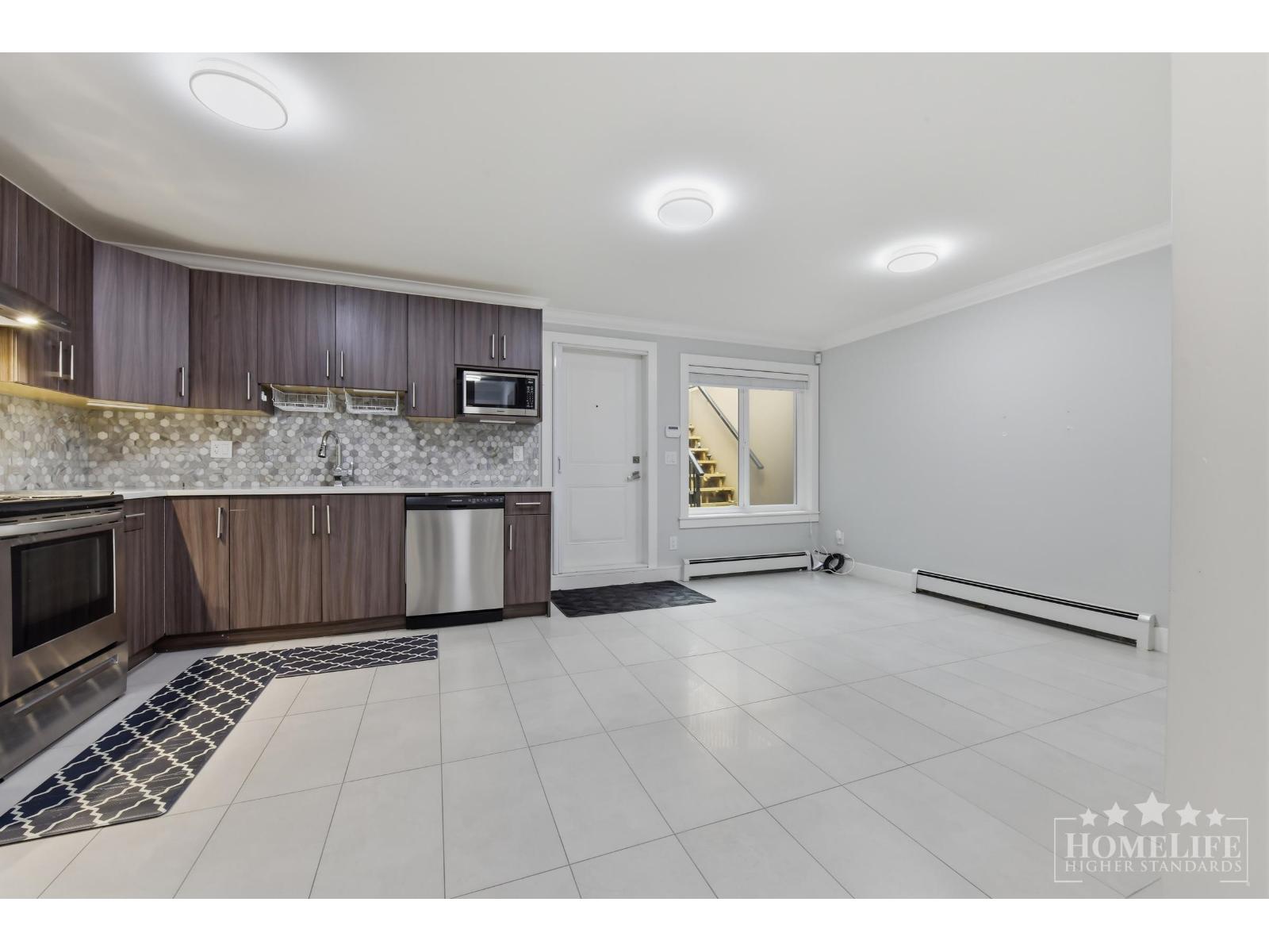 A kitchen with a white tile floor and a white ceiling.