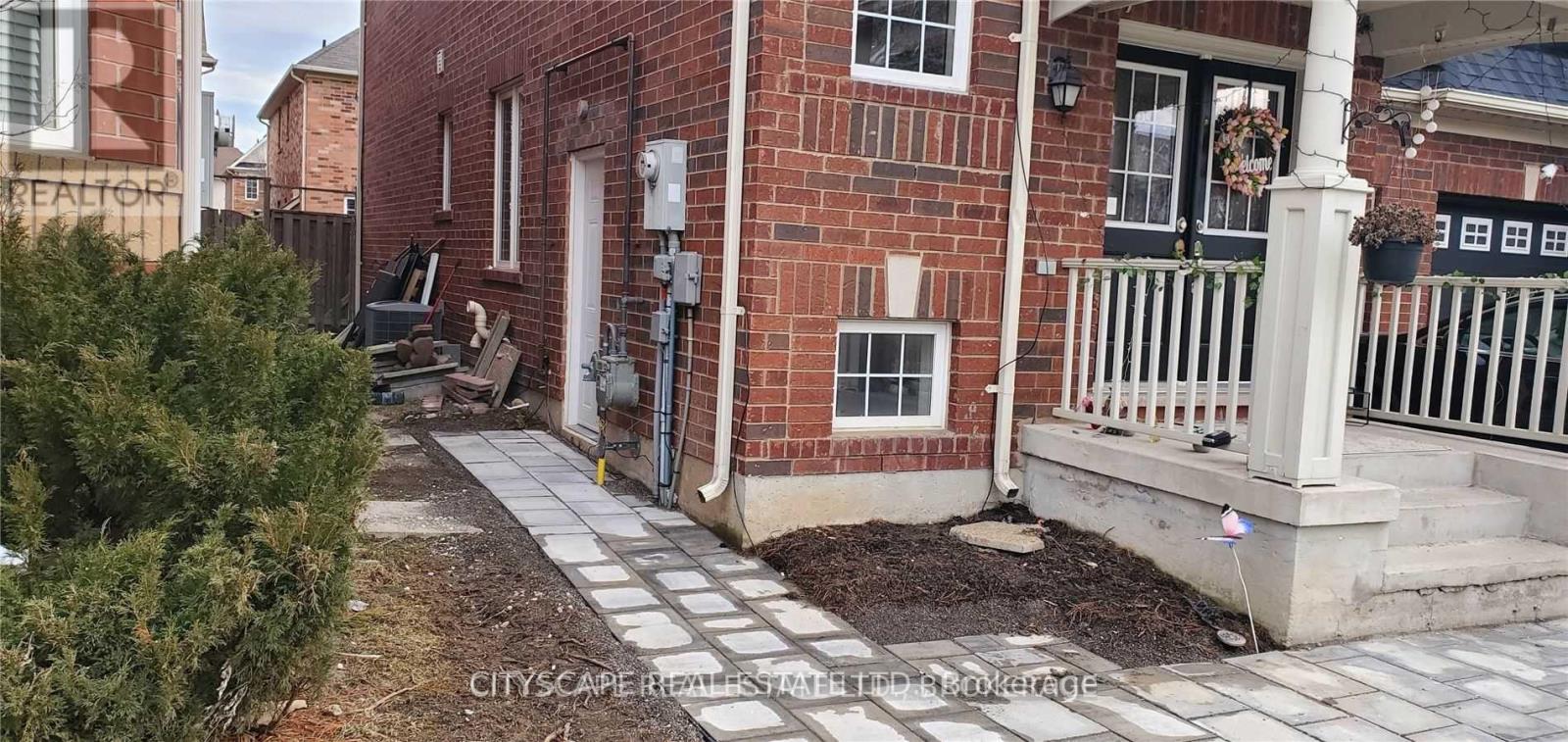 A brick house with a white porch and a white railing.