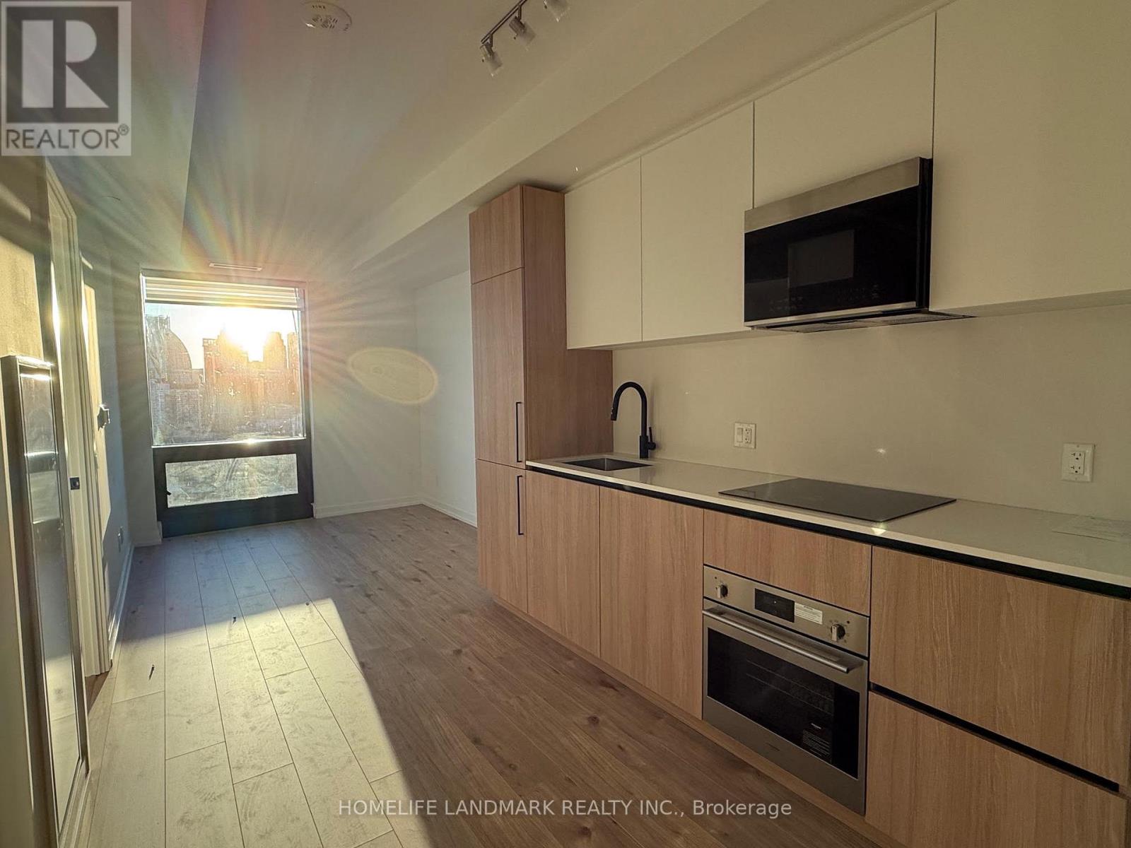 A kitchen with wooden cabinets and a stainless steel oven.