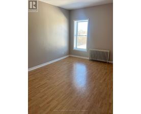 A room with a window and a radiator on the floor.