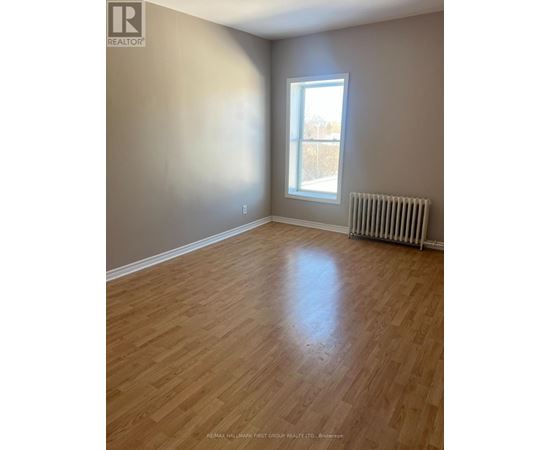 A room with a window and a radiator on the floor.