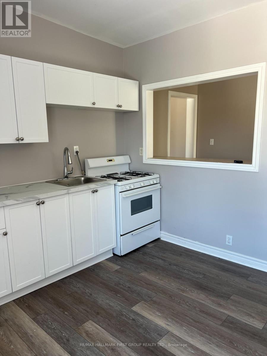 A kitchen with white cabinets and a white stove top oven.