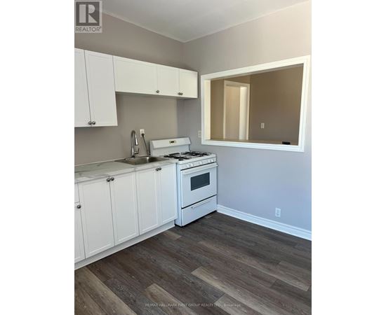 A kitchen with white cabinets and a white stove top oven.