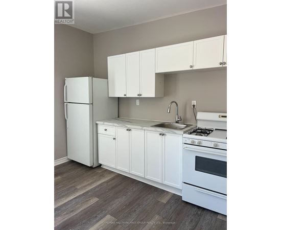 A kitchen with white appliances and cabinets.