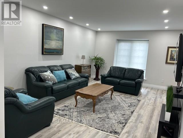 A living room with a black couch and a wooden coffee table.