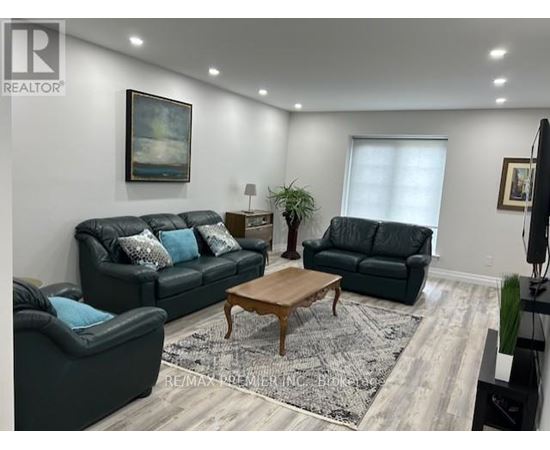 A living room with a black couch and a wooden coffee table.