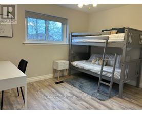 A bedroom with a bunk bed and a desk.