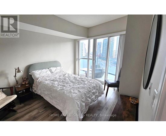 A bedroom with a large bed and a view of the city.