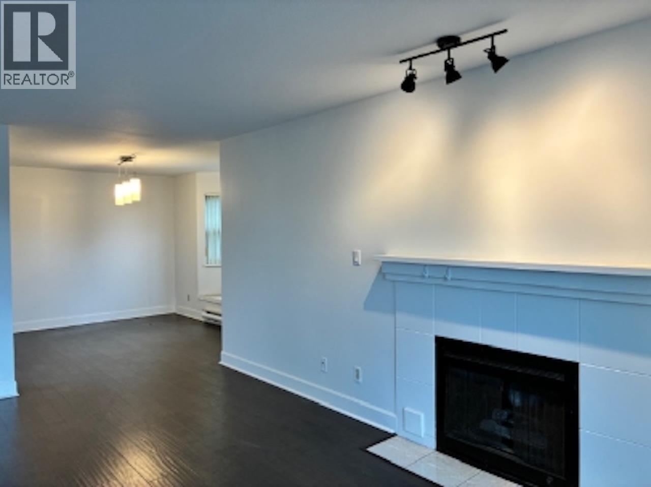 A living room with a fireplace and a Realty logo.