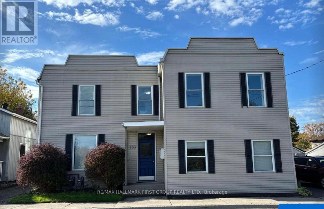 A two-story house with a blue door and windows.