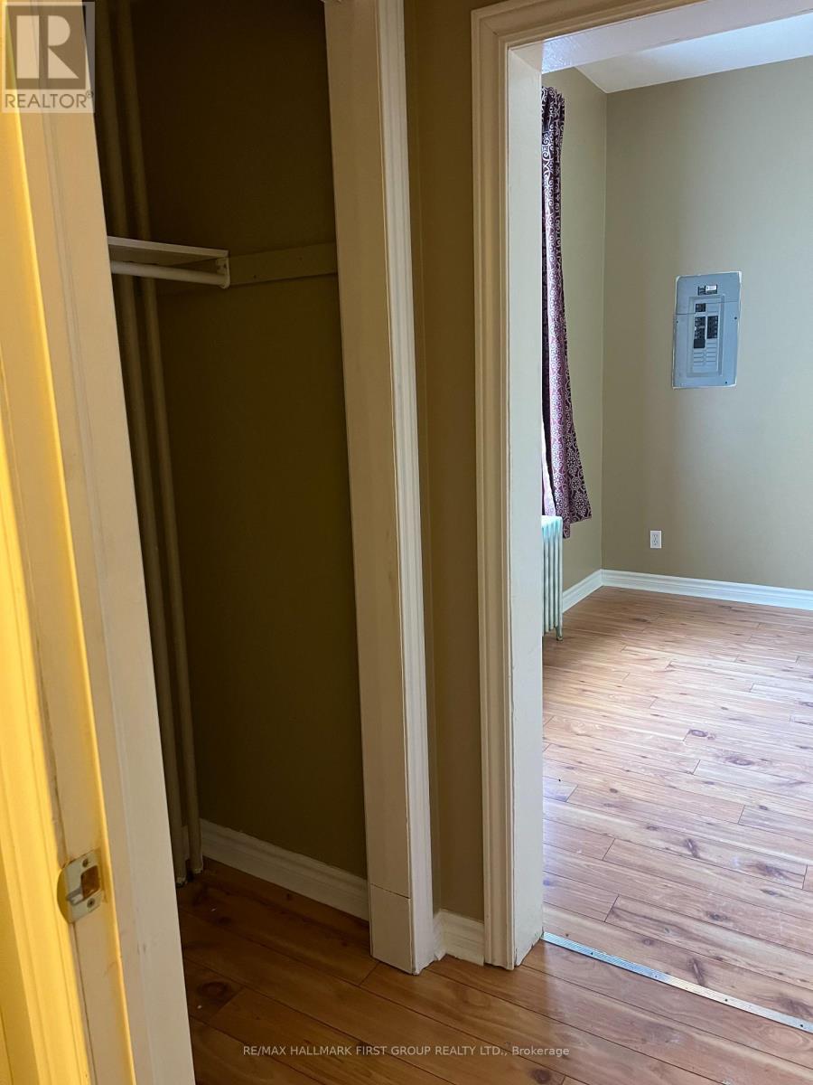 A hallway with wood floors and a white door.