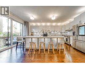 A kitchen with white cabinets and wooden stools.