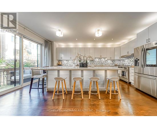 A kitchen with white cabinets and wooden stools.