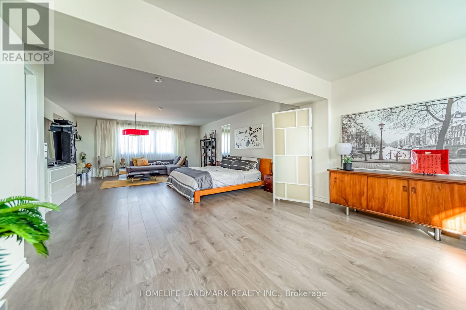 A spacious bedroom with a large bed and a wooden cabinet.