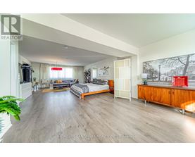 A spacious bedroom with a large bed and a wooden cabinet.