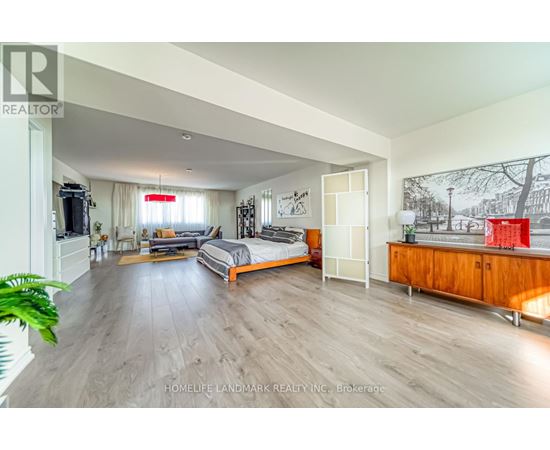 A spacious bedroom with a large bed and a wooden cabinet.