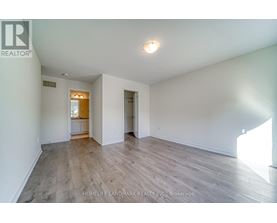 A spacious room with wooden flooring and white walls.