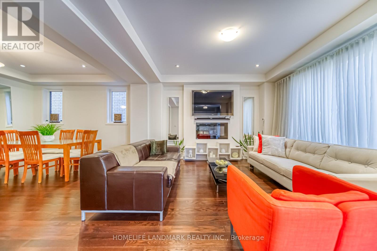 A living room with a white couch and a brown leather chair.