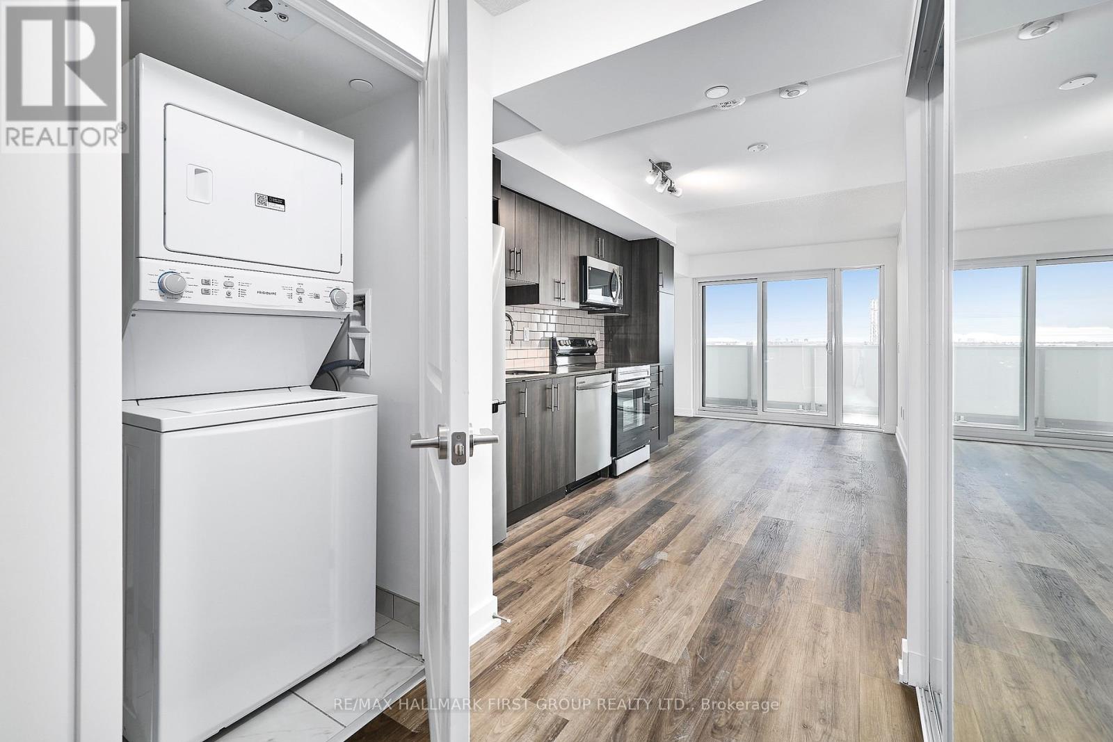 A modern kitchen with a white oven and wooden flooring.