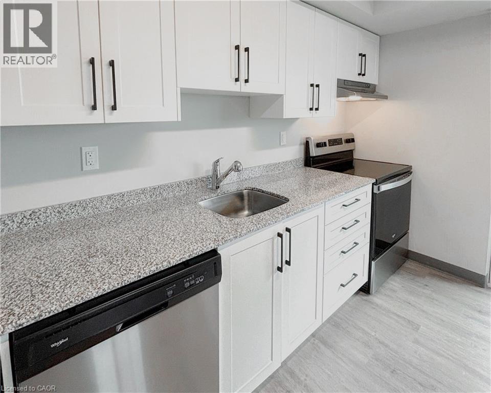 A kitchen with white cabinets and a granite countertop.