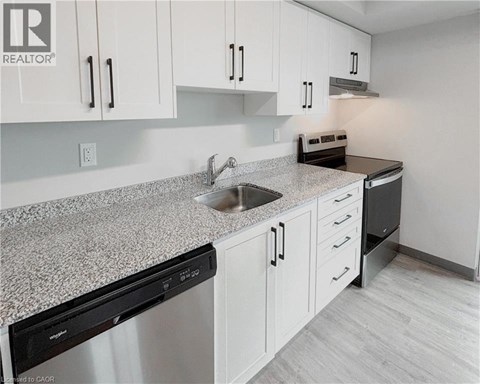 A kitchen with white cabinets and a granite countertop.