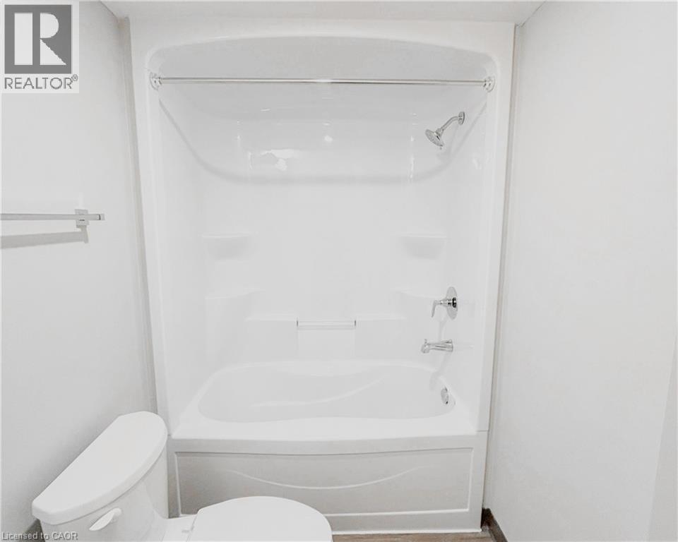 A white bathroom with a toilet and a bathtub.