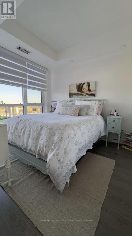 A bedroom with a large bed and a window with blinds.