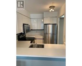 A kitchen with a stainless steel refrigerator and a sink.