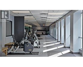 A gym with a row of treadmills and exercise bikes.