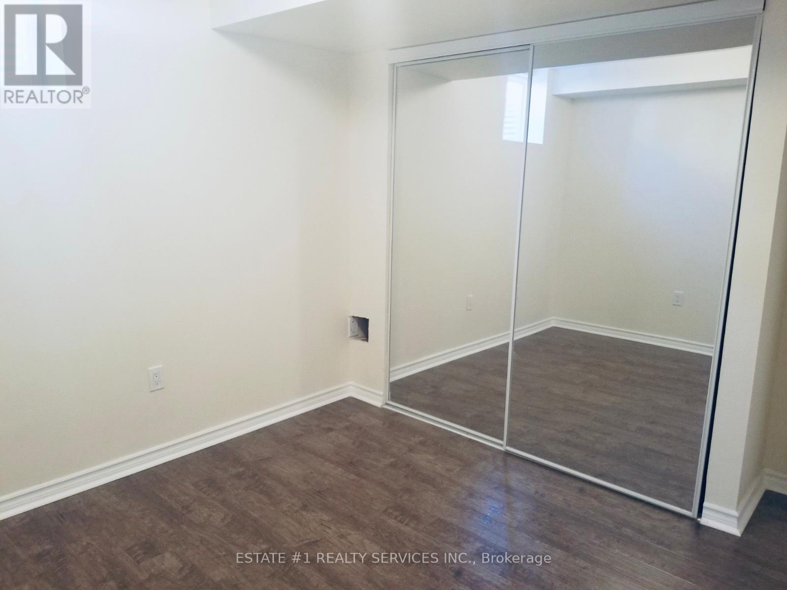 A room with a sliding glass door and wood flooring.