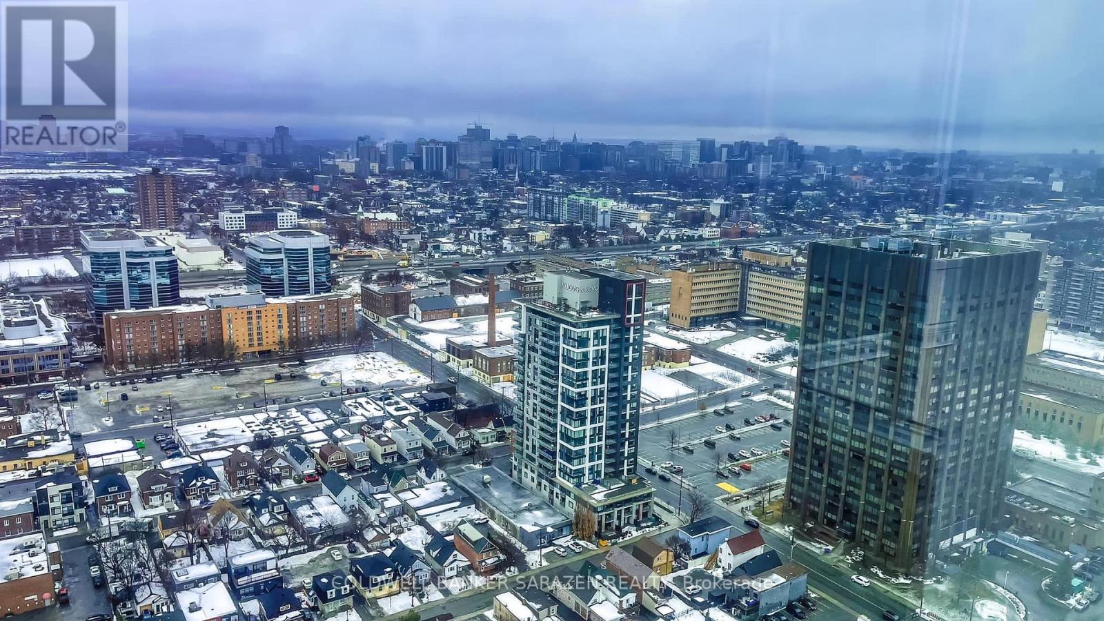 A cityscape with buildings and a REALTOR sign in the corner.