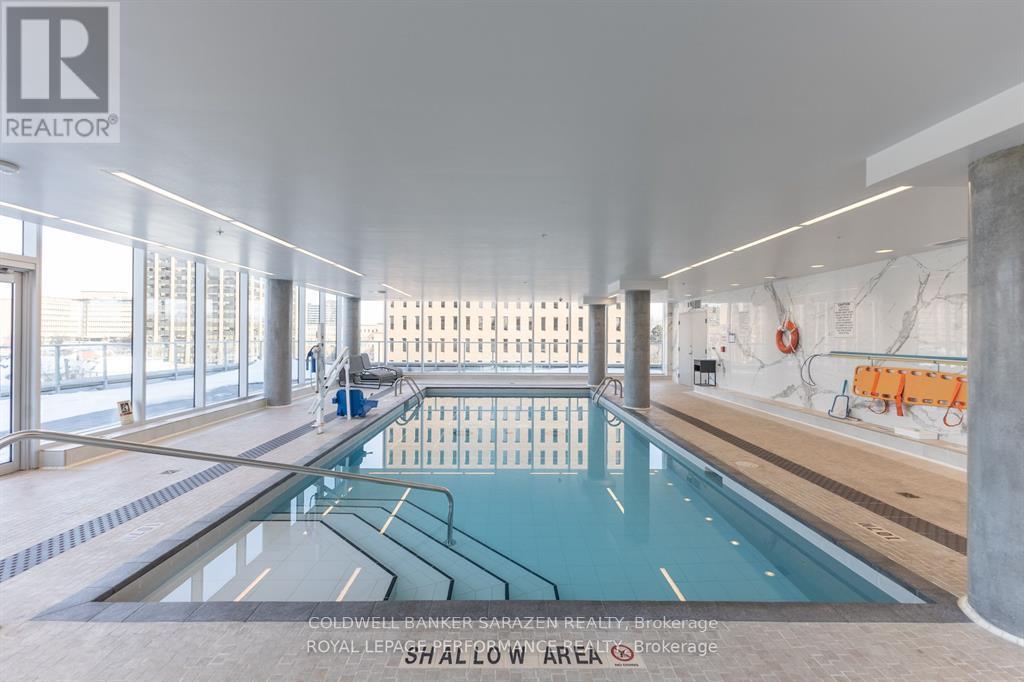 A large indoor swimming pool with a diving board.