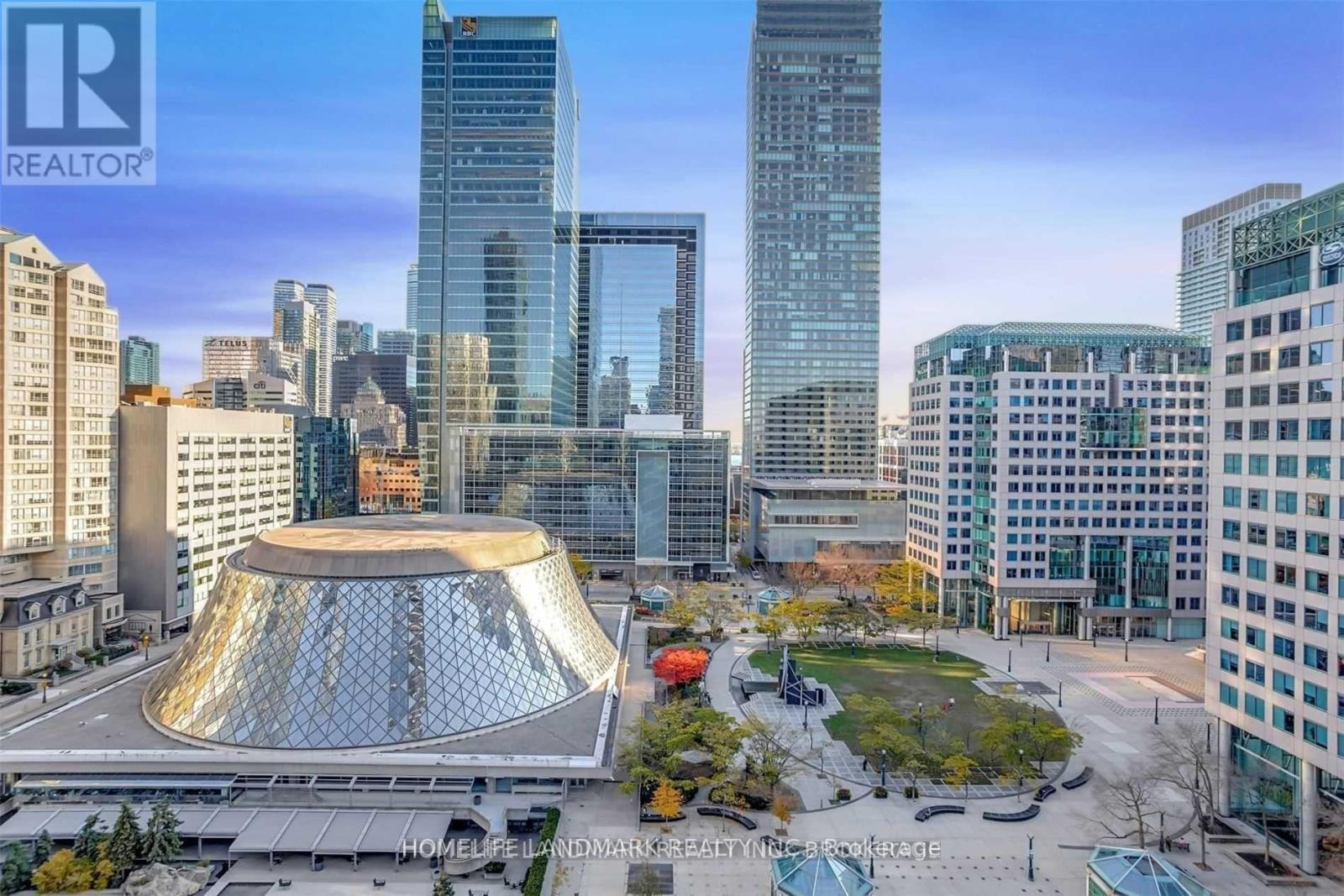 A cityscape with a large glass dome structure in the foreground and skyscrapers in the background.