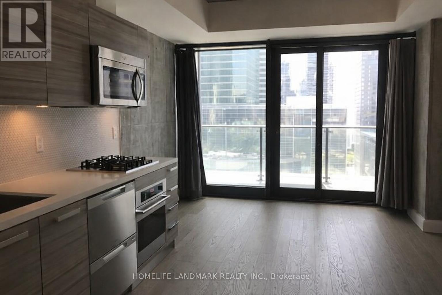 A modern kitchen with a stove top oven and a microwave above it.