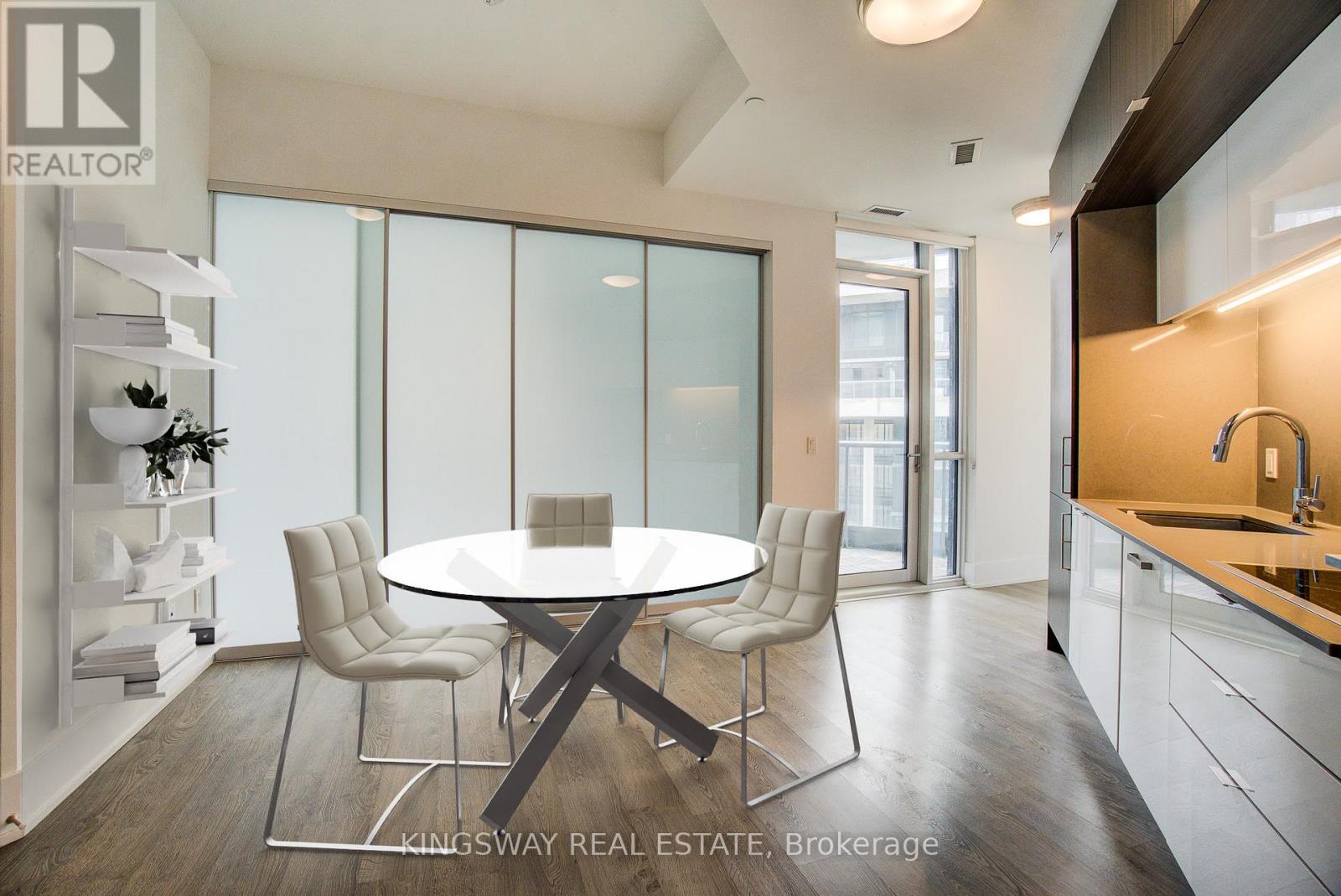 A modern dining room with a glass table and chairs.