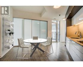 A modern dining room with a glass table and chairs.