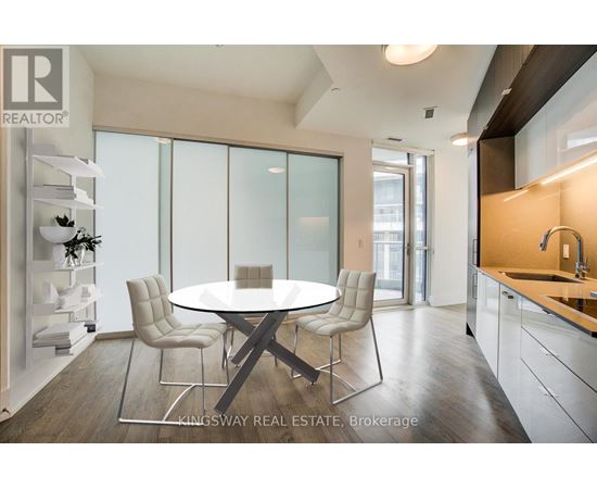 A modern dining room with a glass table and chairs.