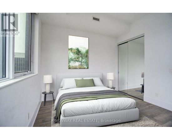 A bedroom with a large bed and a window.