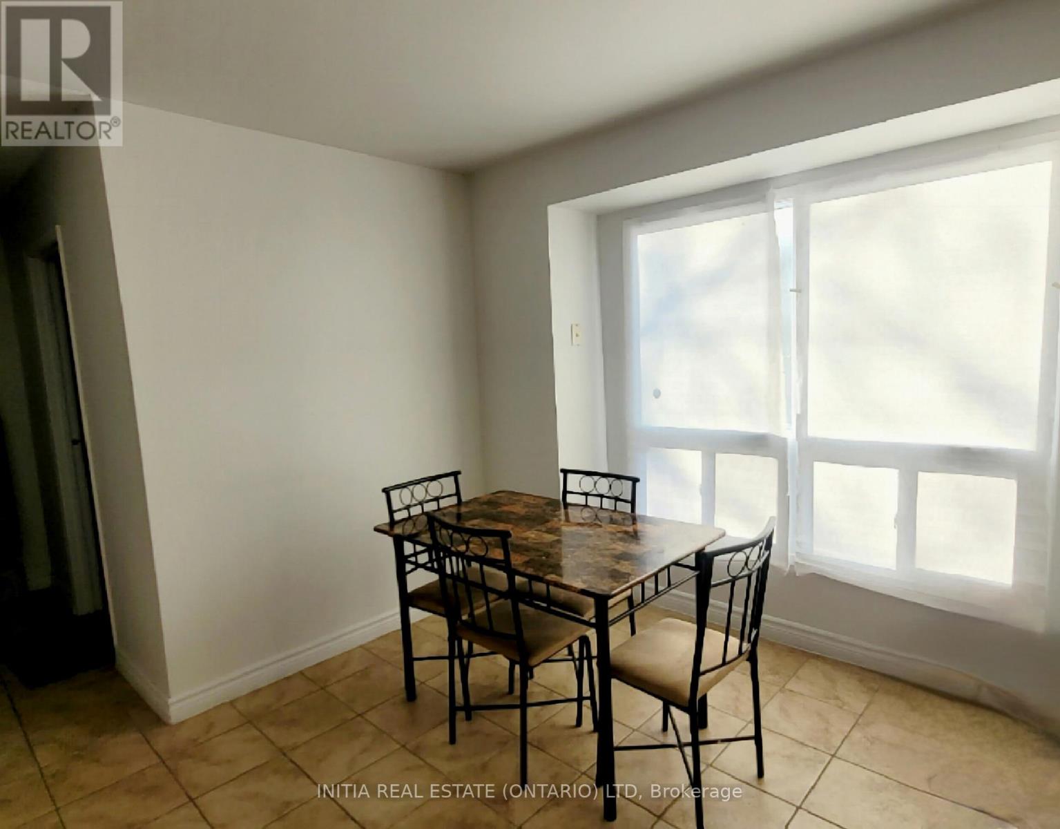 A dining room with a table and chairs.