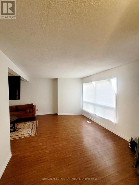 A living room with a couch and a rug.