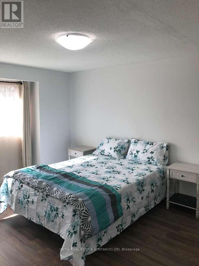 A bedroom with a bed, nightstand, and window.