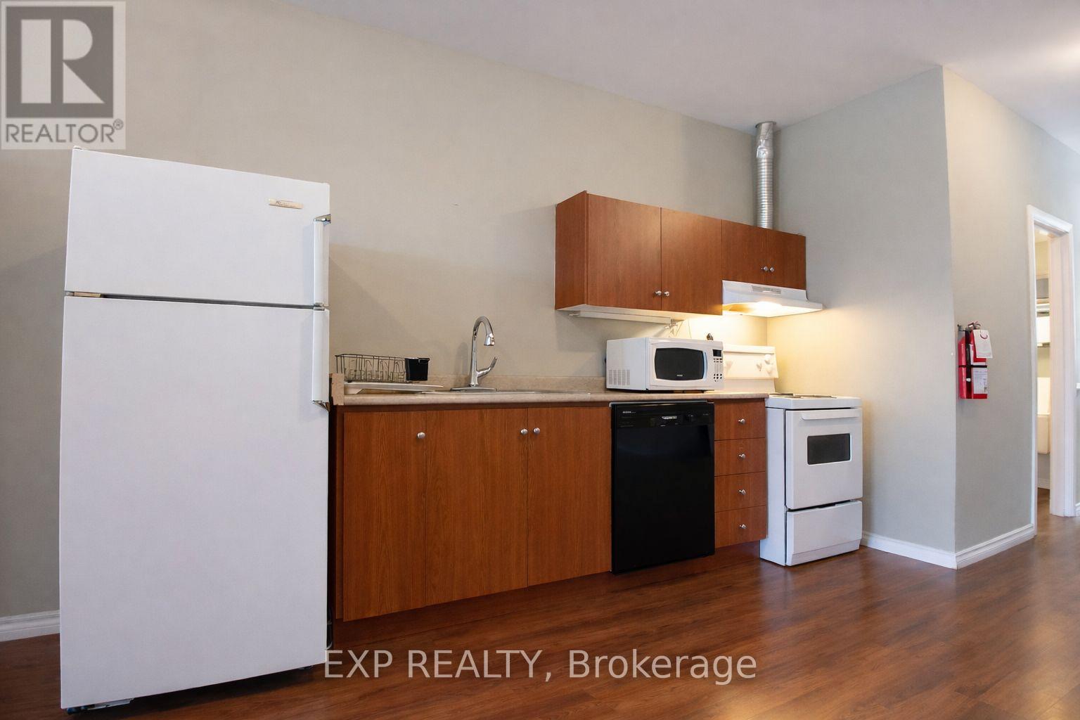 A kitchen with white appliances and wooden cabinets.