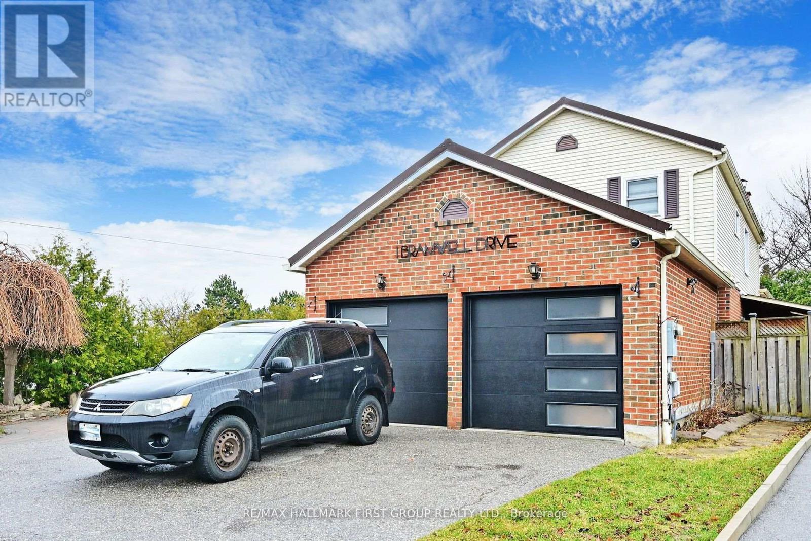A house with a garage and a car parked in front.