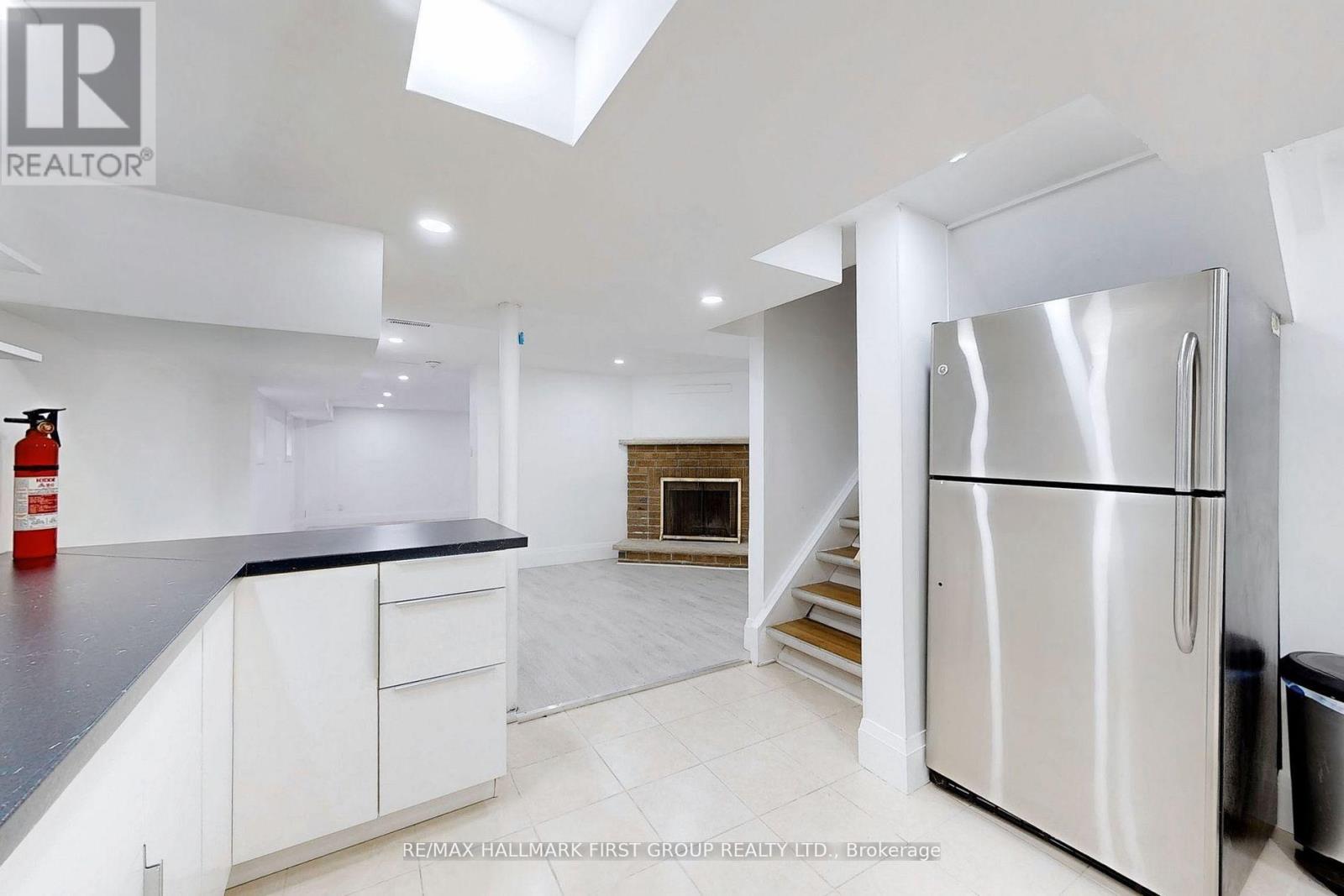 A modern kitchen with white cabinets and a stainless steel refrigerator.