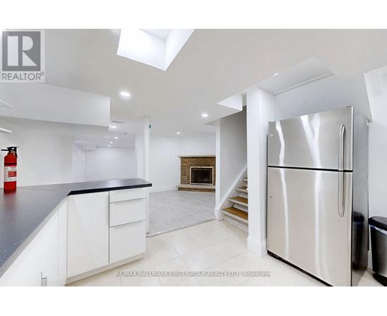A modern kitchen with white cabinets and a stainless steel refrigerator.