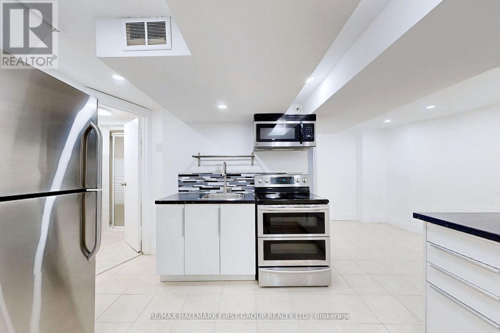 A modern kitchen with stainless steel appliances and white cabinetry.