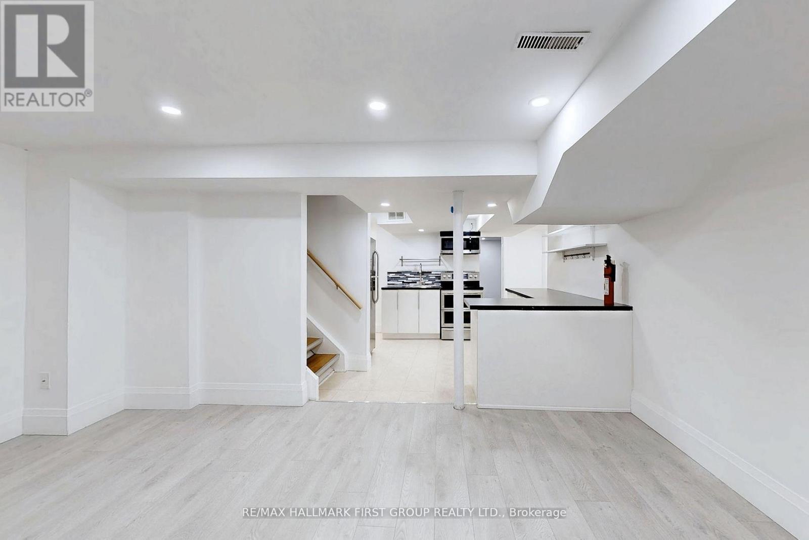 A spacious, empty room with a staircase leading to the next level.