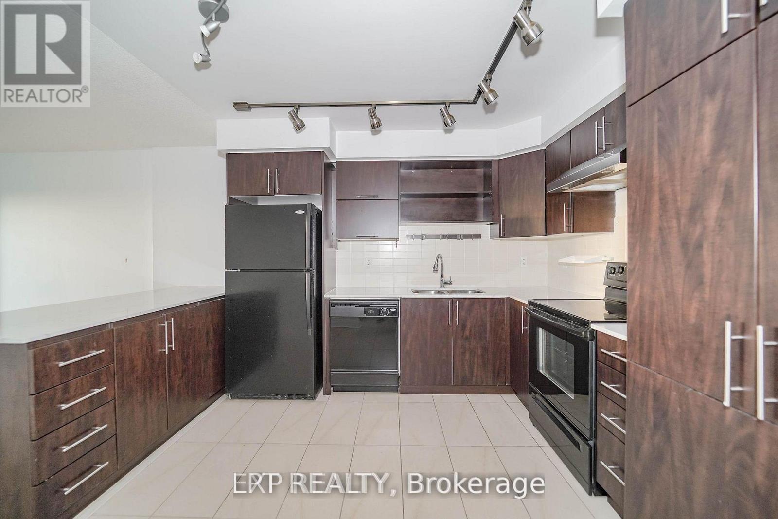 A kitchen with wooden cabinets and black appliances.