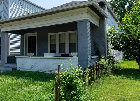 A house with a white porch and a black fence.
