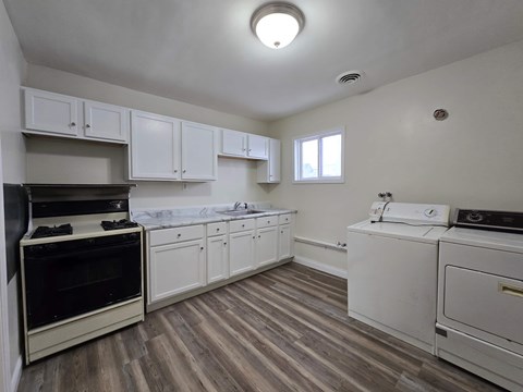 A kitchen with white cabinets and a black oven.